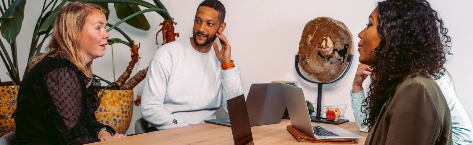 Drie collega's van Intego Zorg in overleg met laptops aan tafel